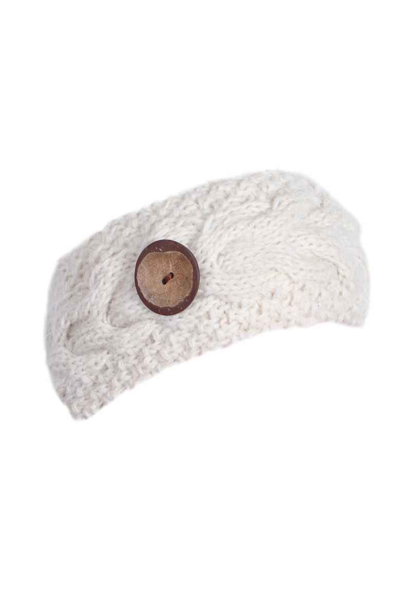 May include: A white knitted headband with a brown button.