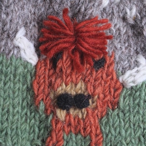 Puede incluir: Un gorro de punto con un dise&ntilde;o rojo, marr&oacute;n y verde. El gorro presenta una imagen de punto de un zorro con una cola tupida.