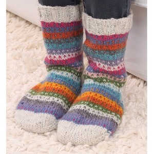 Op de afbeelding: Een paar kleurrijke gestreepte wollen sokken met een witte boord. De sokken zijn gemaakt met een gebreid patroon en hebben een verscheidenheid aan kleuren, waaronder roze, oranje, blauw, groen en grijs.