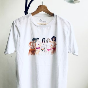 Puede incluir: Camiseta blanca con un gr&aacute;fico de cinco mujeres de pie juntas, cada una con un tipo de cuerpo y tono de piel diferente. Las mujeres llevan ropa interior y tienen los brazos cruzados. El texto "Ohana" est&aacute; impreso en la camiseta.