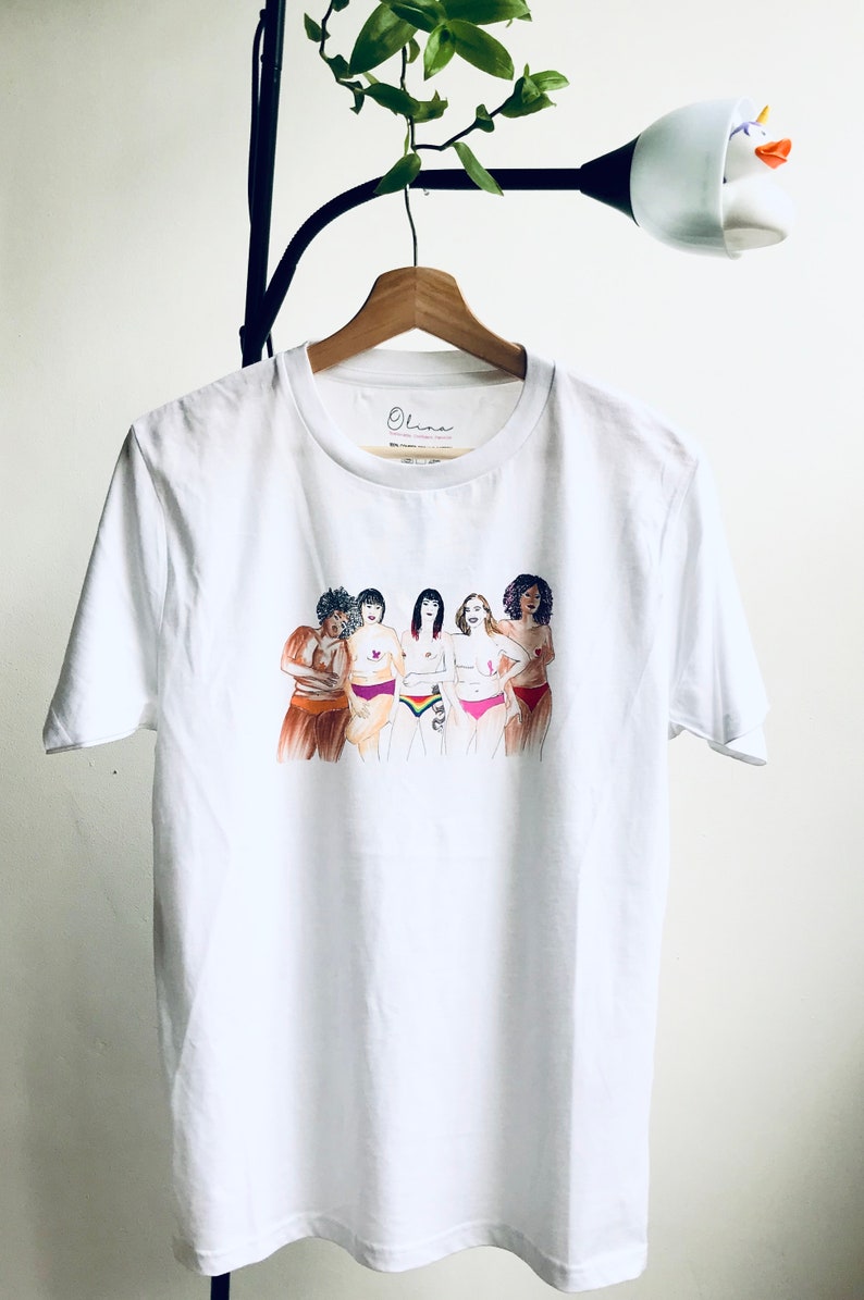 Puede incluir: Camiseta blanca con un gr&aacute;fico de cinco mujeres de pie juntas, cada una con un tipo de cuerpo y tono de piel diferente. Las mujeres llevan ropa interior y tienen los brazos cruzados. El texto "Ohana" est&aacute; impreso en la camiseta.