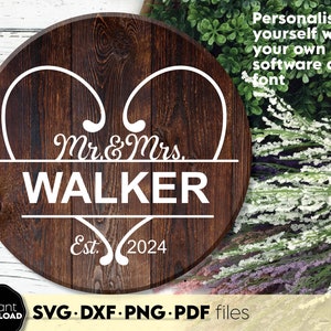 Può includere: Un cartello rotondo in legno con un design a forma di cuore bianco e il testo "Mr. & Mrs. WALKER Est. 2024".