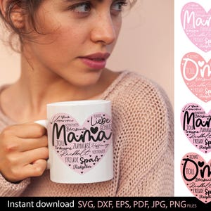 Op de afbeelding: Witte keramische mok met een roze hartontwerp en het woord "Mama" in het midden, omringd door Duitse woorden. De mok wordt door een persoon vastgehouden. Extra hartontwerpen zijn zichtbaar.