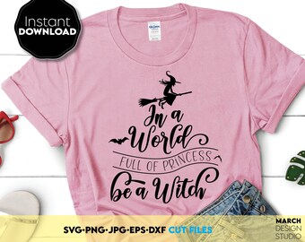 Peut inclure: Un t-shirt rose avec un motif graphique noir qui dit "Dans un monde plein de princesses, sois une sorcière". Le graphique comprend également une silhouette d'une sorcière volant sur un balai.