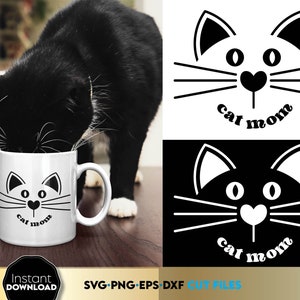 Puede incluir: Una taza de cerámica blanca con un diseño de cara de gato negro y el texto "cat mom" impreso en ella. Un gato negro está bebiendo de la taza.
