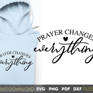 May include: A light blue hoodie with the text "PRAYER CHANGES everything" in black lettering with a small heart symbol. The text is in a cursive font.