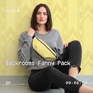 May include: A yellow fanny pack with a black zipper closure and a black strap. The fanny pack features a subtle chevron pattern and is worn across the chest. The text Backrooms Fanny Pack is visible in the lower portion of the image.