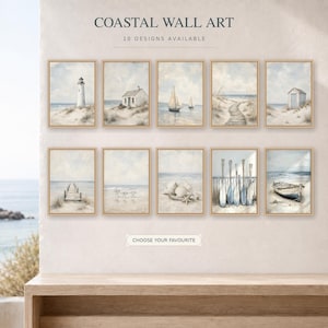 May include: A collection of ten framed coastal wall art prints featuring light blue and beige nautical scenes including a lighthouse, sailboats, a beach path, a wooden pier, seashells, oars, and a small boat, with the text COASTAL WALL ART.