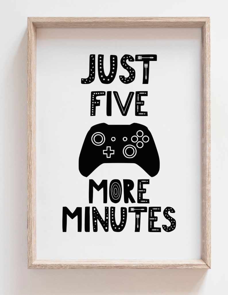 Puede incluir: Una l&aacute;mina enmarcada con el texto negro JUST FIVE MORE MINUTES y un gr&aacute;fico de un mando de videojuego negro en el centro. Las letras tienen varios patrones, incluyendo estrellas, flechas y l&iacute;neas sobre un fondo blanco en un marco de madera clara.