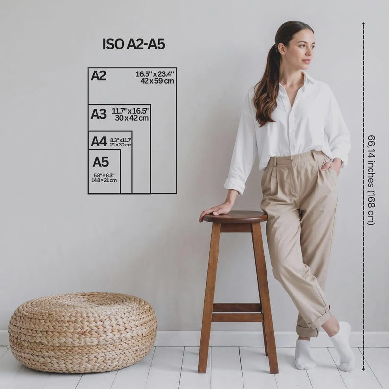 Puede incluir: Una camisa blanca de botones y pantalones beige con una tabla de tallas ISO A2-A5 en pulgadas y cent&iacute;metros, una l&iacute;nea de medici&oacute;n vertical que indica 168 cm de altura, junto a un otomano redondo trenzado.