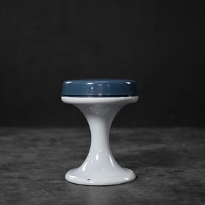 Op de afbeelding: Een witte en blauwe flesstopper. De bovenkant is donkerblauw en de basis is wit. De stopper heeft een afgeronde bovenkant en een uitlopende basis. Strak en modern ontwerp voor diverse flessen.