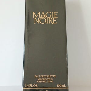 Könnte beinhalten: Eine rechteckige, schwarze Schachtel mit Lancôme Magie Noire Eau de Toilette. Der goldfarbene Text auf der Schachtel lautet "MAGIE NOIRE" und "EAU DE TOILETTE VAPORISATEUR NATURAL SPRAY". Die Schachtel enthält 100 ml.