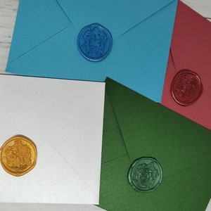 May include: Four envelopes with different coloured paper and wax seals. The envelopes are white, blue, green, and red. The wax seals are gold, blue, green, and red.