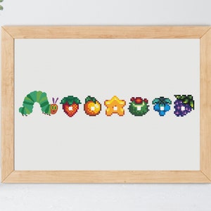 May include: A framed print of a green caterpillar with a red face, followed by a red strawberry, an orange, a yellow star, a green leaf, a blue blueberry, and a purple bunch of grapes. The print is on a white background.