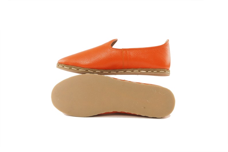 May include: Orange leather slip-on shoes with a brown sole and white stitching.