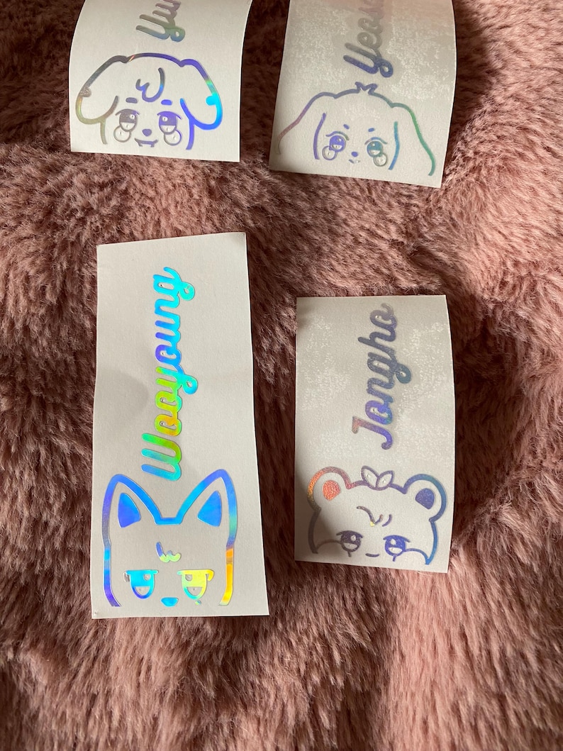 K&ouml;nnte beinhalten: Vier schimmernde holografische Aufkleber mit Comic-Tiergesichtern und Namen. Die Aufkleber zeigen einen Hund, eine Katze und zwei B&auml;ren. Die Namen auf den Aufklebern sind "Yu", "Yeon", "Wooyoung" und "Jeongho".