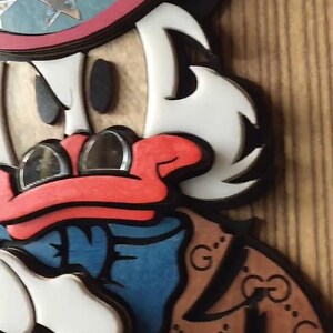 May include: A cartoon duck wearing a red, white, and blue top hat with stars and a brown jacket with a black and white GG pattern. The duck has a red beak and white feathers.