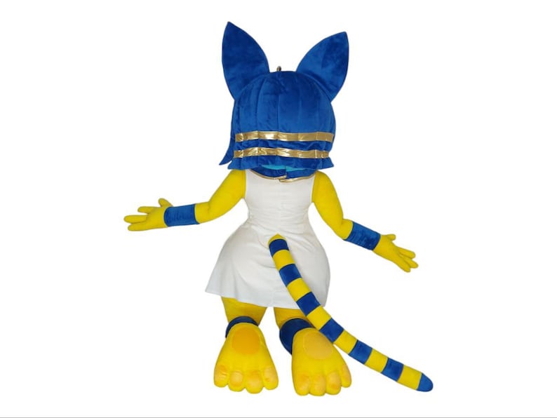 May include: A yellow and blue plush mascot costume of a cat wearing a white dress and a blue headpiece with gold trim. The costume has a long tail with yellow and blue stripes.