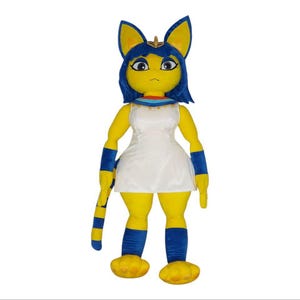 May include: A plush toy shaped like a cat with blue hair, wearing a white dress and blue leg warmers. The toy has yellow fur and a gold collar.