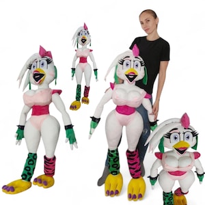 May include: Plush toy of a white chicken character with pink, green, and yellow accents. The character has a pink bow, a pink top, and green and black patterned leggings. The plush toy is standing with other similar plush toys.
