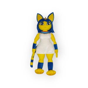 May include: A plush toy of a yellow cat-like creature with blue hair and a white dress. The toy has a long tail and is wearing a gold necklace.
