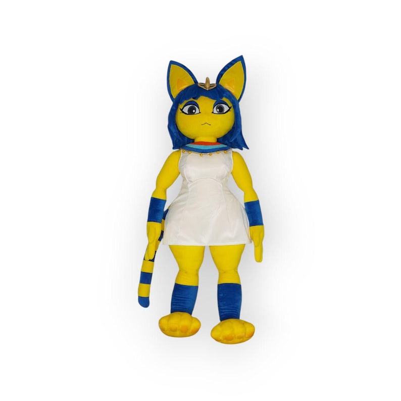 May include: A plush toy of a yellow cat-like creature with blue hair and a white dress. The toy has a long tail and is wearing a gold necklace.