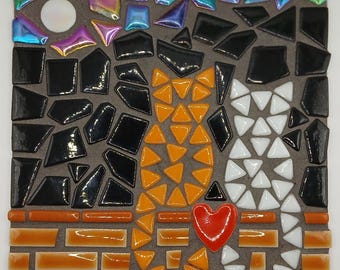 May include: A mosaic artwork featuring a cat design. The cat is composed of orange, black, and white tiles, with a red heart. The background is a mix of dark gray and brick-colored tiles, with iridescent tiles at the top. The artwork is square.