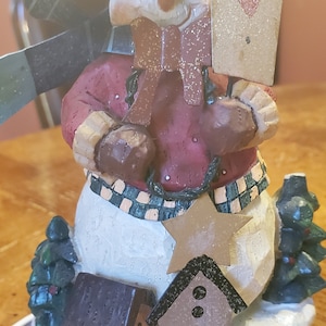 Snowman Circled with Birdhouses and Trees with Single Candle Light