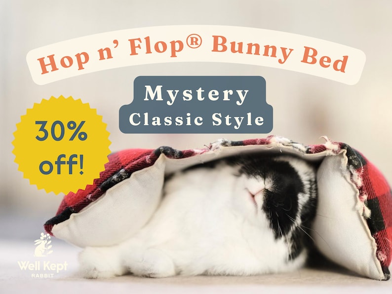 May include: A black and white rabbit is sleeping in a red and black plaid bunny bed. The bed is labeled "Hop n' Flop&reg; Bunny Bed" and "Mystery Classic Style". A yellow starburst with the text "30% off!" is in the top left corner.
