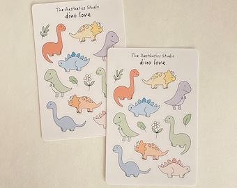 May include: Two sheets of stickers featuring cute cartoon dinosaurs in various colors. The stickers are labeled "The Aesthetics Studio dino love".