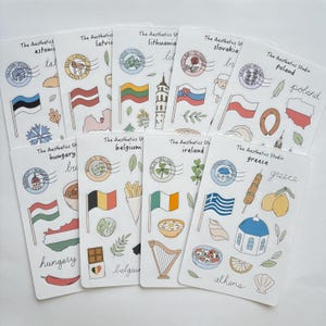 Puede incluir: Una colección de hojas de pegatinas blancas con ilustraciones de banderas, monumentos y comida de varios países. Cada hoja incluye el texto "The Aesthetics Studio" y el nombre de un país, como Estonia, Letonia y Lituania.