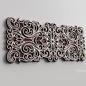 May include: An intricate decorative wall art piece in brown and white with a floral design. The art piece is made of wood and has a 3D effect.