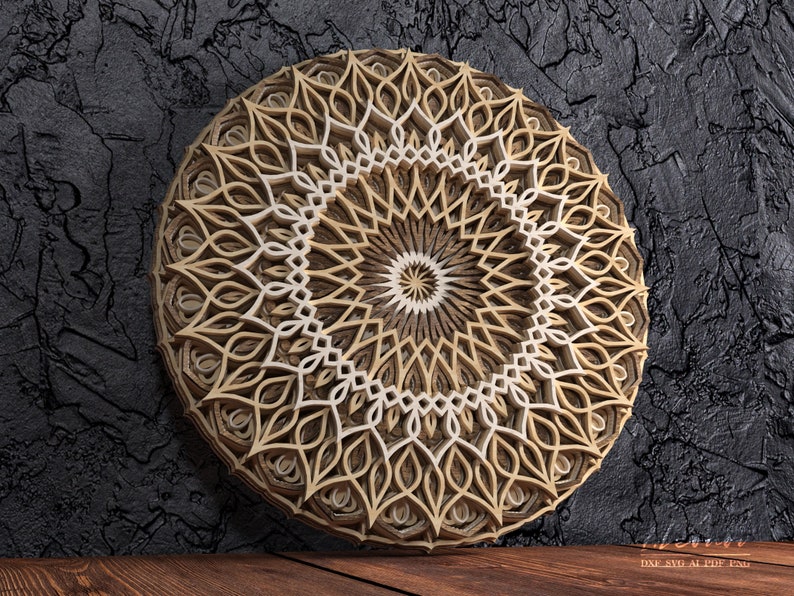 K&ouml;nnte beinhalten: Ein mehrschichtiges Mandala-Wandkunstwerk aus Holz. Das kreisf&ouml;rmige Design weist komplizierte Muster in Beige- und Wei&szlig;t&ouml;nen auf, wodurch ein dreidimensionaler Effekt entsteht. Das Kunstwerk wird vor einem dunklen, strukturierten Hintergrund pr&auml;sentiert.
