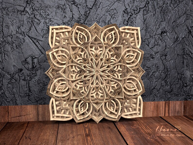 May include: A detailed wooden mandala with intricate cutouts, creating a layered and dimensional design. The mandala is a light brown color and has a symmetrical pattern.