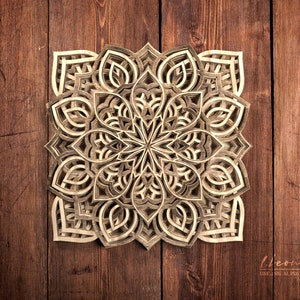 May include: A detailed, intricate wooden mandala with a layered, geometric design. The mandala is made of light brown wood and has a symmetrical pattern.
