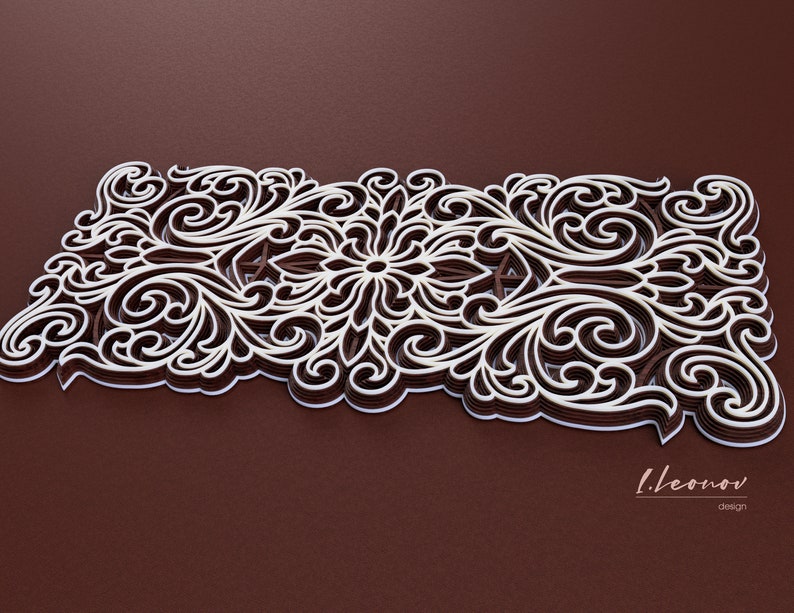 May include: An intricate paper cut design in white and brown, featuring a floral pattern. The design is layered and has a 3D effect. The background is a dark brown.