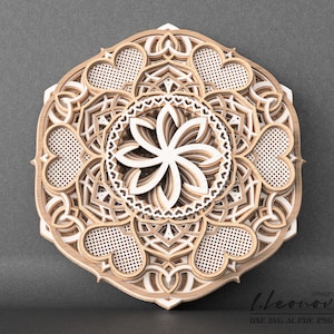 May include: A layered wooden mandala with a white center and intricate designs. The mandala features a flower-like pattern in the center and hearts around the outer edge.