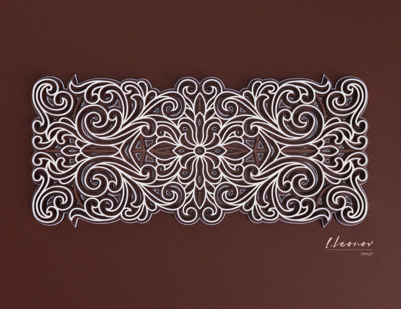 May include: An intricate white design with a floral pattern on a brown background. The design is symmetrical and features a repeating pattern of swirls and leaves. The design is framed by a white border.
