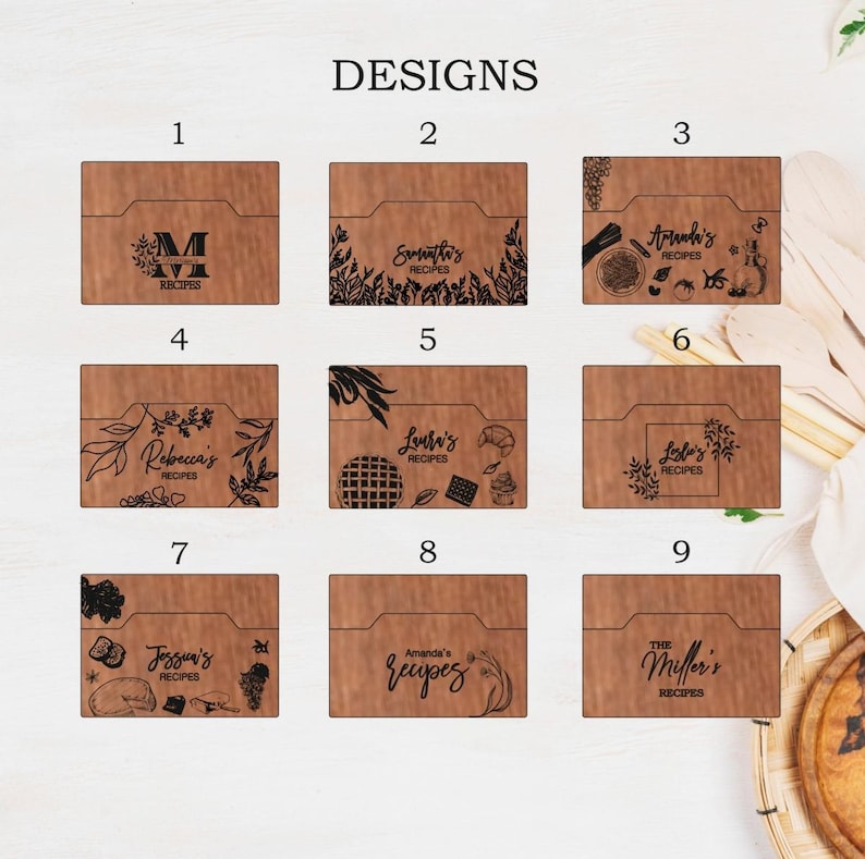 May include: Wooden recipe card holders with various engraved designs. Designs include names like "Samantha's Recipes," "Laura's Recipes," and "The Miller's Recipes." Each holder has a unique decorative element, such as floral patterns or food illustrations.