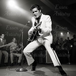 May include: A black and white photo of a man in a white suit playing a guitar on stage. He is singing into a microphone and has a band behind him.