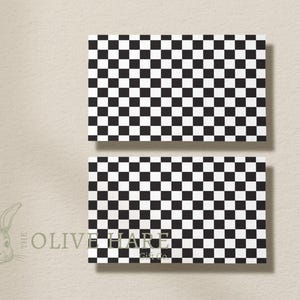 Può includere: Due carte rettangolari con un motivo a scacchi bianco e nero. Le carte hanno una superficie liscia.