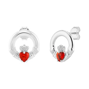 Può includere: Un paio di orecchini a lobo Claddagh argentati. Ogni orecchino presenta un cuore rosso, una corona e mani. Il cuore è al centro, con la corona sopra e le mani che lo abbracciano. Sfondo bianco.