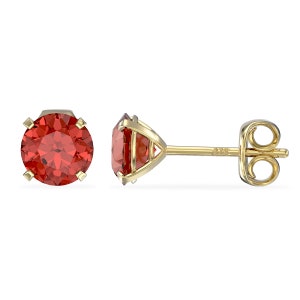 May include: A pair of gold stud earrings with a red gemstone in the centre. The earrings have a post and butterfly back.