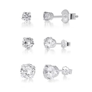 May include: Three pairs of silver stud earrings, each with a clear, round gemstone. The earrings have a sparkling stone set in a silver bezel. The image shows the earrings on a white background, highlighting their reflective properties.