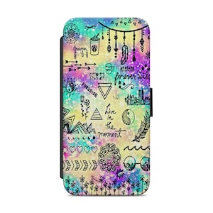 Może przedstawiać: Kolorowe etui na telefon z nadrukiem galaktyki i czarnymi wzorami w stylu doodle. Wzory obejmują strzałki, pióra, serca, góry, kubek do kawy, symbol yin yang oraz tekst "forever wild", "paradise", "live in the moment" i "dreamer".