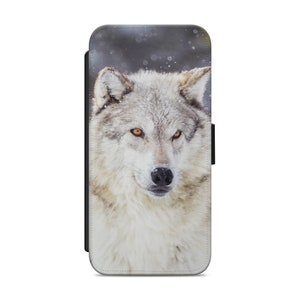 May include: A white wolf with yellow eyes stares intensely at the camera. The wolf is in a snowy forest setting.
