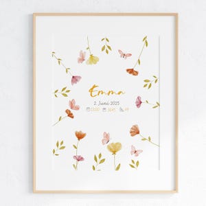 K&ouml;nnte beinhalten: Ein gerahmter Aquarelldruck mit dem Namen "Emma" in goldener Schrift, umgeben von zarten Blumen und Schmetterlingen in Rosa-, Orange- und Gelbt&ouml;nen. Das Datum und die Uhrzeit sind ebenfalls enthalten.
