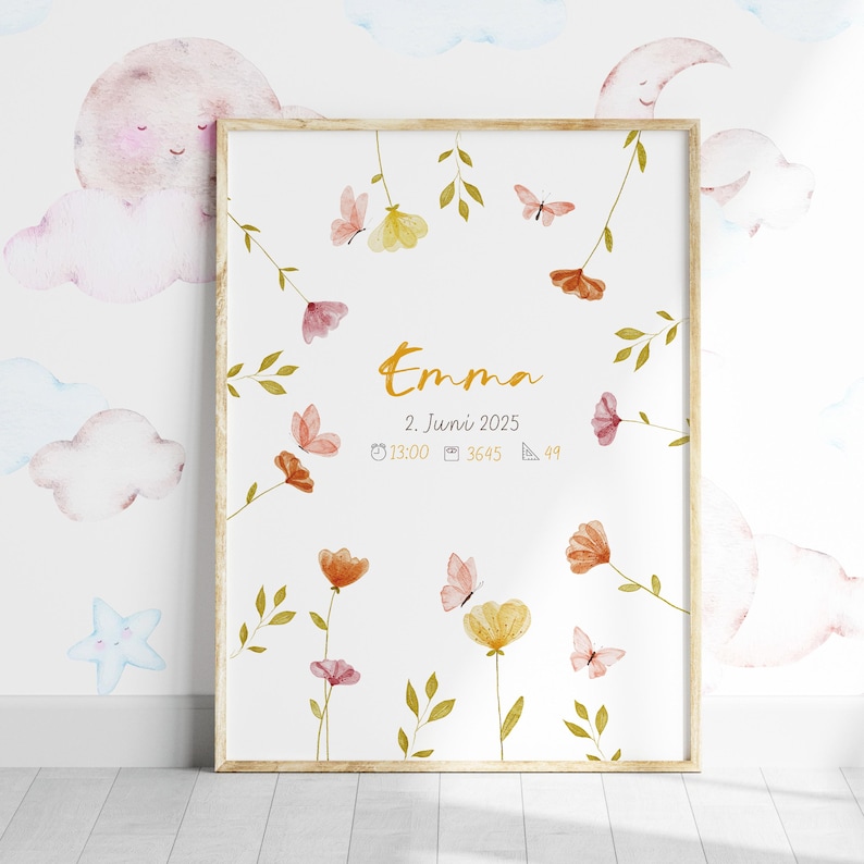 K&ouml;nnte beinhalten: Ein gerahmter Druck mit dem Namen "Emma" in goldener Schrift, verziert mit Aquarellblumen und Schmetterlingen. Der Druck enth&auml;lt das Datum "2. Juni 2025" und weitere Details. Der Rahmen ist hellbraun.