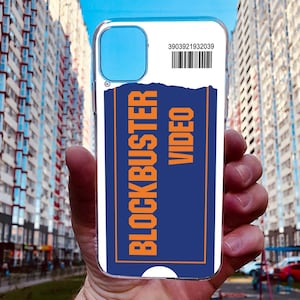 May include: A white phone case with a blue and orange Blockbuster Video ticket design. The ticket has the text "Blockbuster Video" and the number "3903921932039".