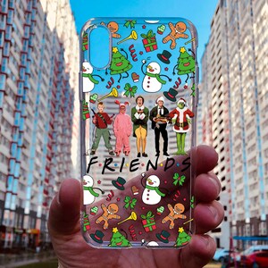 May include: A clear phone case with a Christmas theme featuring characters from the movie. The case has a white background with red, green, and blue accents.